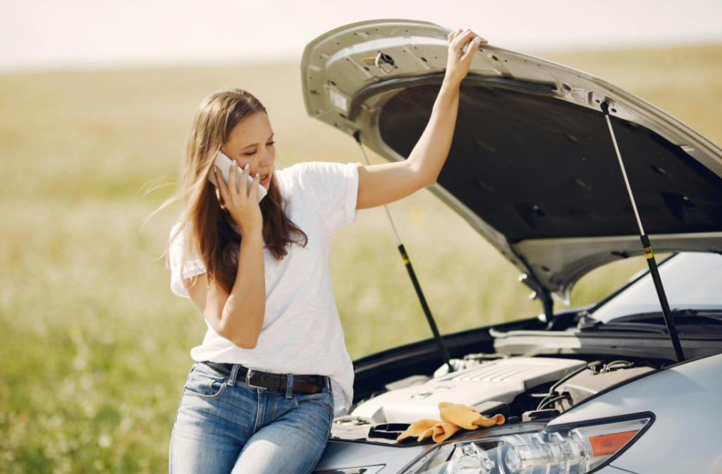 A girl is calling a emergency towing service because her car breaksdown.